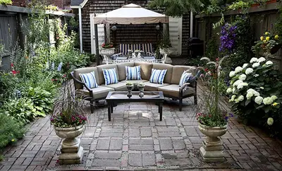a patio with a couch and a table and flowers at Morgan State House Inn in Albany