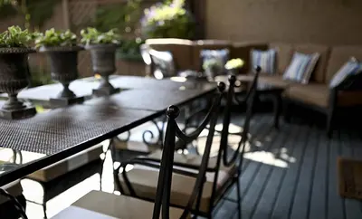 a table and chairs on a deck with plants at Morgan State House Inn in Albany