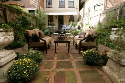 a patio with chairs and a table and flowers at Morgan State House Inn in Albany