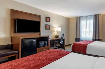 a hotel room with two beds and a flat screen tv at Comfort Inn Glenmont - Albany South in Glenmont
