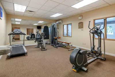 a gym with several treadmills and elliptical machines at Comfort Inn Glenmont - Albany South in Glenmont