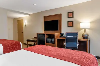 a hotel room with two beds and a flat screen tv at Comfort Inn Glenmont - Albany South in Glenmont
