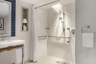 a white bathroom with a shower and a sink at Hilton Club New York in New York