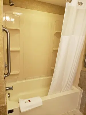 a bathroom with a bath tub with a shower curtain at Baymont by Wyndham Pompton Plains/Wayne in Pompton Plains