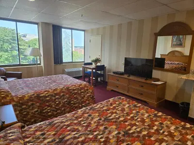 a hotel room with two beds and a television at Amsterdam Hotel in Stamford