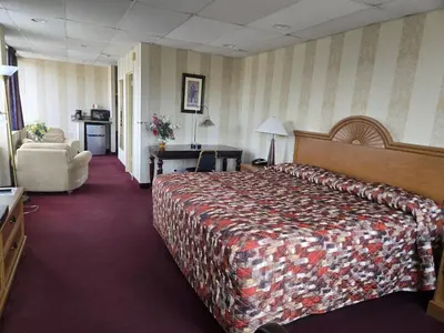 a hotel room with a large bed and a chair at Amsterdam Hotel in Stamford