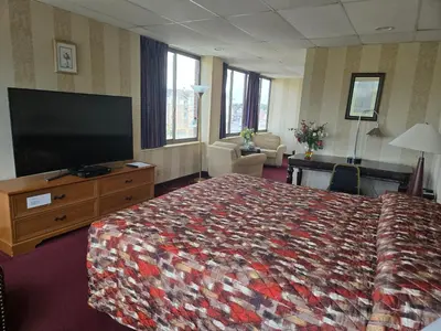 a hotel room with a bed and a flat screen tv at Amsterdam Hotel in Stamford