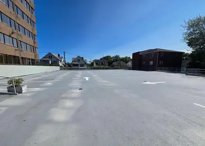 an empty parking lot with white arrows on the street at Amsterdam Hotel in Stamford