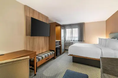 a hotel room with a bed and a flat screen tv at The Clocktower Hotel Latham - North Albany, an Ascend Collection Hotel in Cohoes