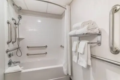 a bathroom with a shower and a bath tub with towels at The Clocktower Hotel Latham - North Albany, an Ascend Collection Hotel in Cohoes