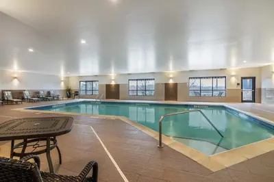 a large swimming pool with a table and chairs at The Clocktower Hotel Latham - North Albany, an Ascend Collection Hotel in Cohoes