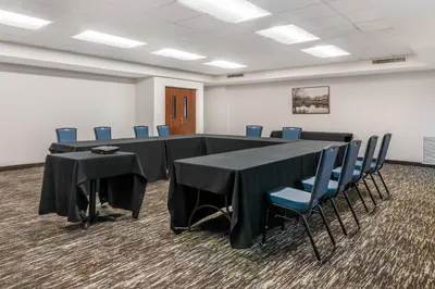 a conference room with a long table and blue chairs at The Clocktower Hotel Latham - North Albany, an Ascend Collection Hotel in Cohoes