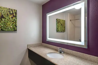 a bathroom with a sink and a mirror at La Quinta by Wyndham Latham Albany Airport in Latham