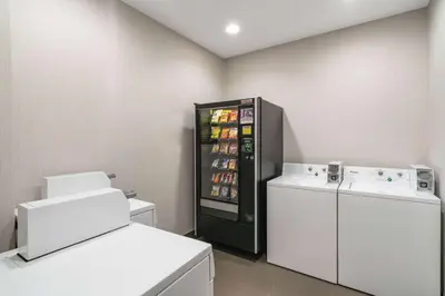 a refrigerator and a washing machine in a room at La Quinta by Wyndham Latham Albany Airport in Latham