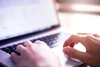 a person is typing on a laptop computer at La Quinta by Wyndham Latham Albany Airport in Latham
