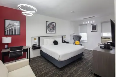 a hotel room with a bed and a desk at Ramada by Wyndham Jersey City in Jersey City