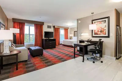 a hotel room with a bed and a desk at Homewood Suites by Hilton Long Island-Melville in Plainview
