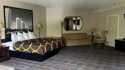 a hotel room with a bed and a couch at Super 8 by Wyndham Albany in Albany
