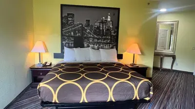 a large bed in a room with two lamps at Super 8 by Wyndham Albany in Albany