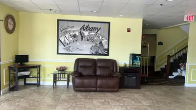 a waiting room with a brown leather reclining chair at Super 8 by Wyndham Albany in Albany