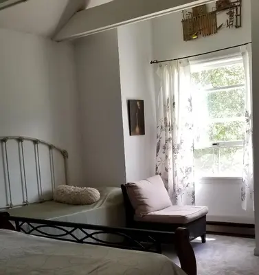 a bedroom with a bed and a chair and a window at Hunter Mt Amazing Views Catskills! 5 Bedrooms! Best Choice! in Hunter