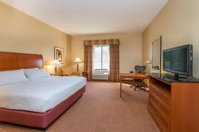 a hotel room with a bed and a flat screen tv at Hilton Garden Inn Fishkill in Fishkill