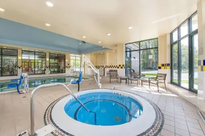 a large indoor pool with a hot tub in a building at Hilton Garden Inn Fishkill in Fishkill