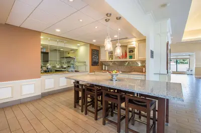 a large kitchen with a large table and chairs at Hilton Garden Inn Fishkill in Fishkill