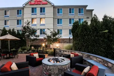 a hotel with a fire pit in front of a building at Hilton Garden Inn Melville in Plainview