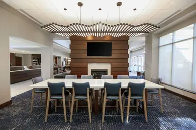 a conference room with a table and chairs and a tv at Hilton Garden Inn Melville in Plainview