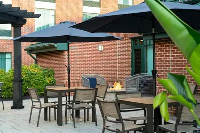 an outdoor patio with tables and chairs with umbrellas at Homewood Suites by Hilton Hartford South-Glastonbury in Glastonbury