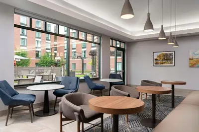 a waiting room with tables and chairs and windows at Homewood Suites by Hilton Hartford South-Glastonbury in Glastonbury
