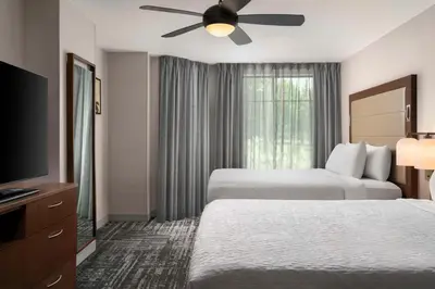 a hotel room with two beds and a flat screen tv at Homewood Suites by Hilton Hartford South-Glastonbury in Glastonbury