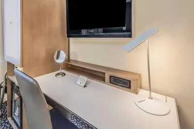 a room with a table with a television on a wall at The Historic Blue Angel Hotel Lexington Ave, an Ascend Collection in New York