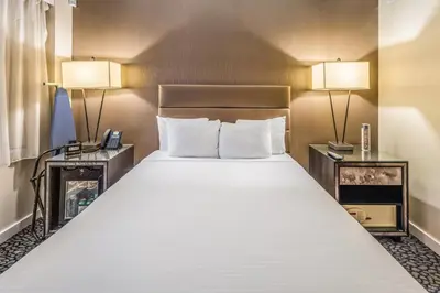a large bed in a hotel room with two lamps at The Historic Blue Angel Hotel Lexington Ave, an Ascend Collection in New York