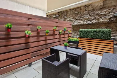 a wooden fence with potted plants and a table at The Historic Blue Angel Hotel Lexington Ave, an Ascend Collection in New York