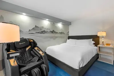 a bedroom with a bed and a mural of mountains at Blue - A Modern Hotel, an Ascend Collection Hotel in West Springfield