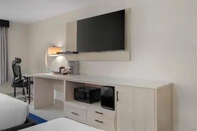 a hotel room with a desk with a tv on the wall at Blue - A Modern Hotel, an Ascend Collection Hotel in West Springfield
