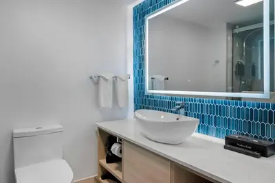 a bathroom with a sink and a mirror and a toilet at Blue - A Modern Hotel, an Ascend Collection Hotel in West Springfield