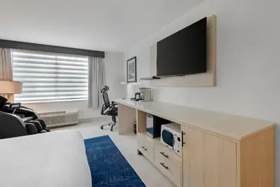 a living room with a flat screen tv on a wall at Blue - A Modern Hotel, an Ascend Collection Hotel in West Springfield