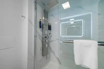 a bathroom with a shower with a glass door at Blue - A Modern Hotel, an Ascend Collection Hotel in West Springfield
