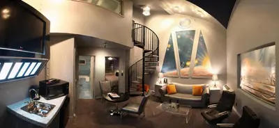 a living room with a couch and a spiral staircase at The Roxbury in Roxbury