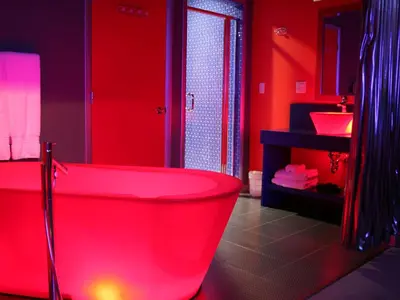 a red bathroom with a tub and a sink at The Roxbury in Roxbury
