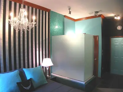 a room with a chandelier and a bed with blue pillows at The Roxbury in Roxbury