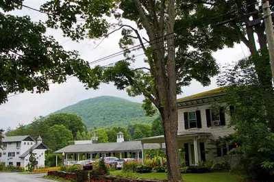 a house with a mountain in the background at The Roxbury in Roxbury