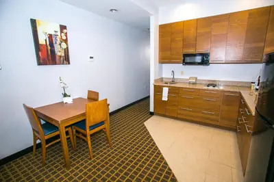 a kitchen with a wooden table and a kitchen with a microwave at Pointe Plaza Hotel in Brooklyn