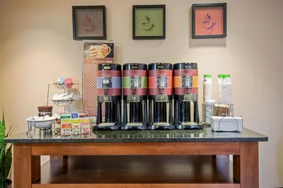 a table with a group of coffee machines on it at Hampton Inn West Springfield in West Springfield