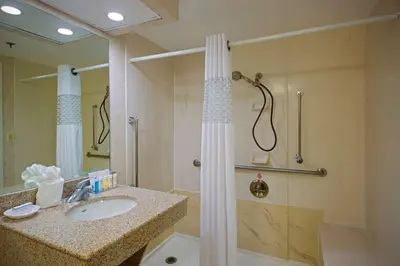 a bathroom with a shower and a sink and a shower at Hampton Inn West Springfield in West Springfield