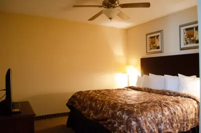 a hotel room with a bed and a ceiling fan at Rodeway Inn & Suites East Windsor in East Windsor