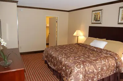 a hotel room with a bed and a table and lamp at Rodeway Inn & Suites East Windsor in East Windsor
